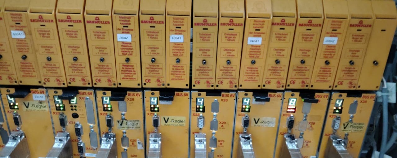 Clear frontal workshop photo of BaumÃ¼ller yellow power modules and V-Regler / BUS 6V drive row